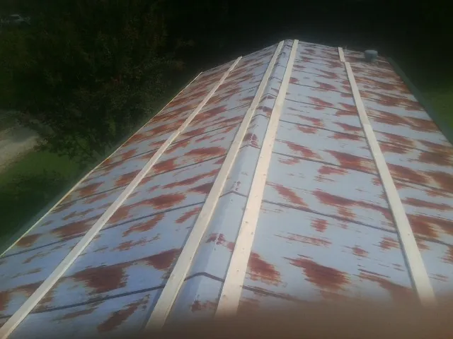Rusted metal roof panels with new wood purlins before replacement — Storm Damage Roof Repair in Massena by Roofing Brothers