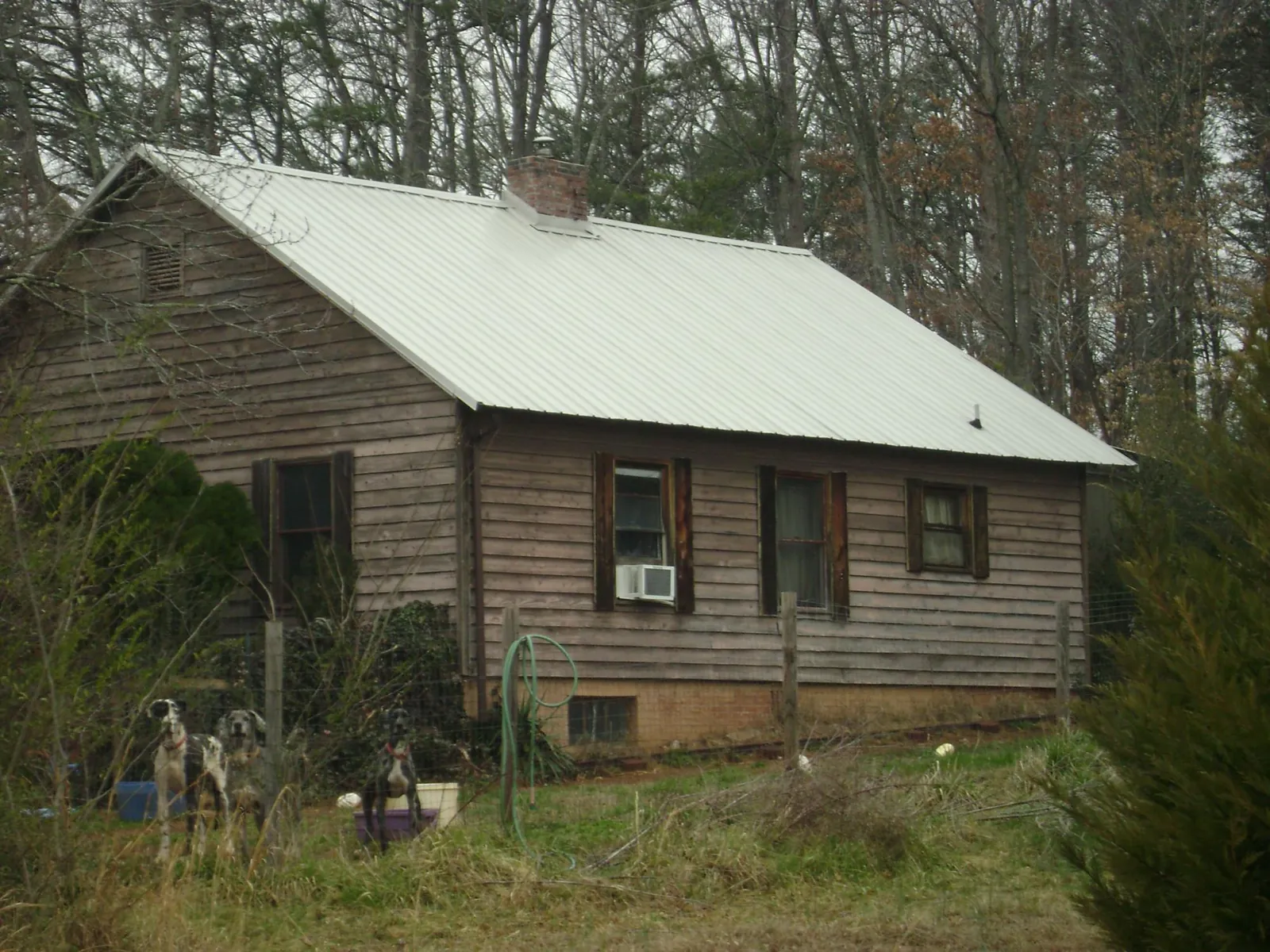 White metal roof on an old wood sided farmhouse, from a Metal Roof Installation job in Massena